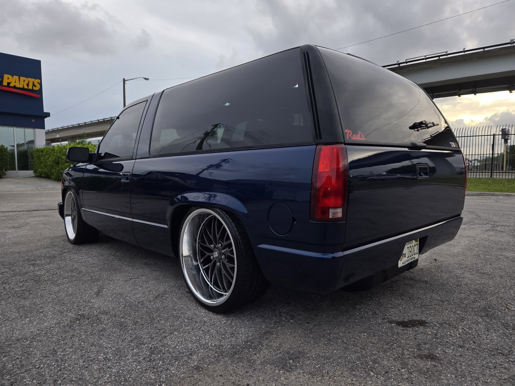 Black lowered Chevy Suburban rear three-quarter view with custom wheels