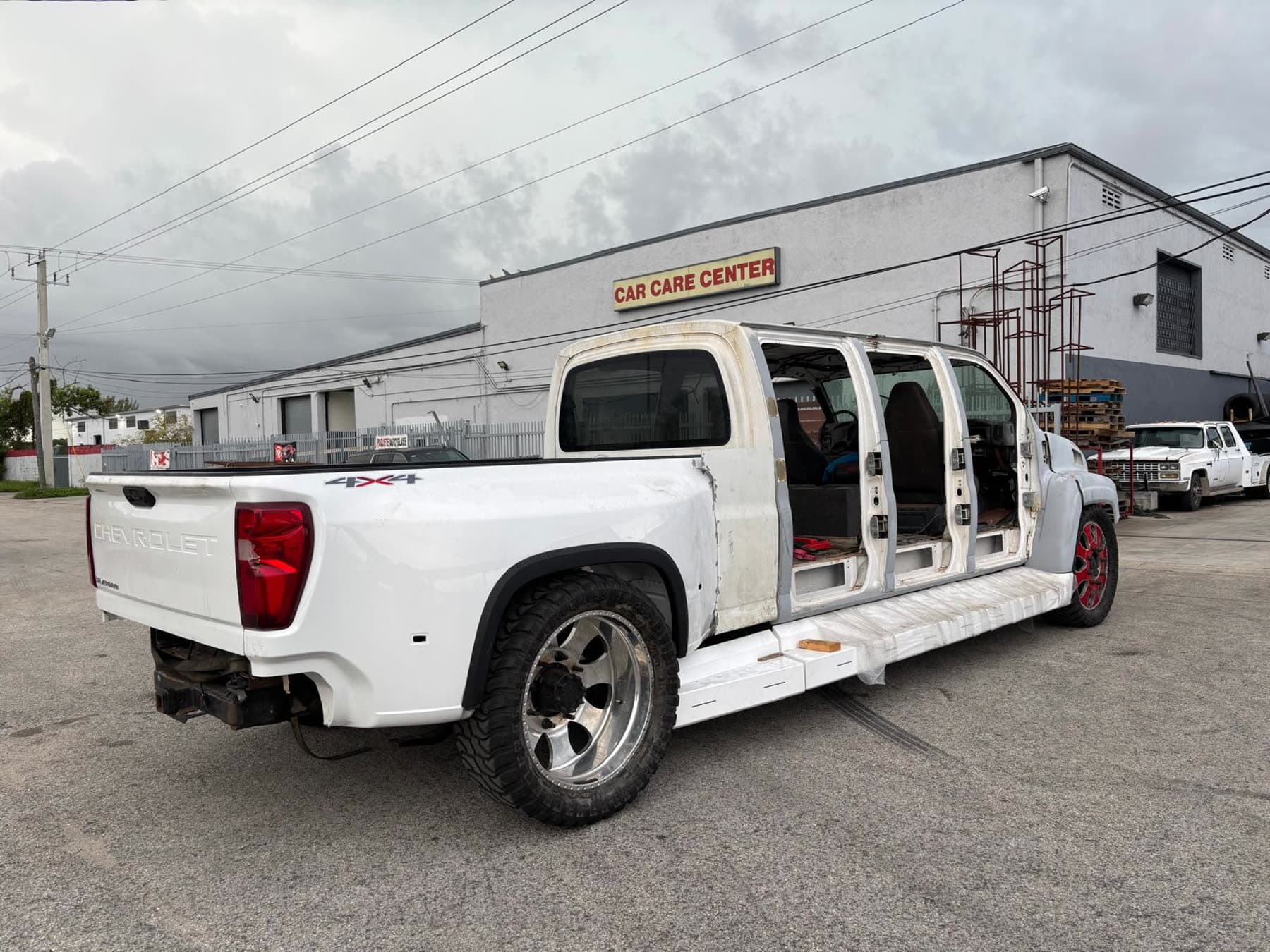 White Chevy dually project truck rear three-quarter view